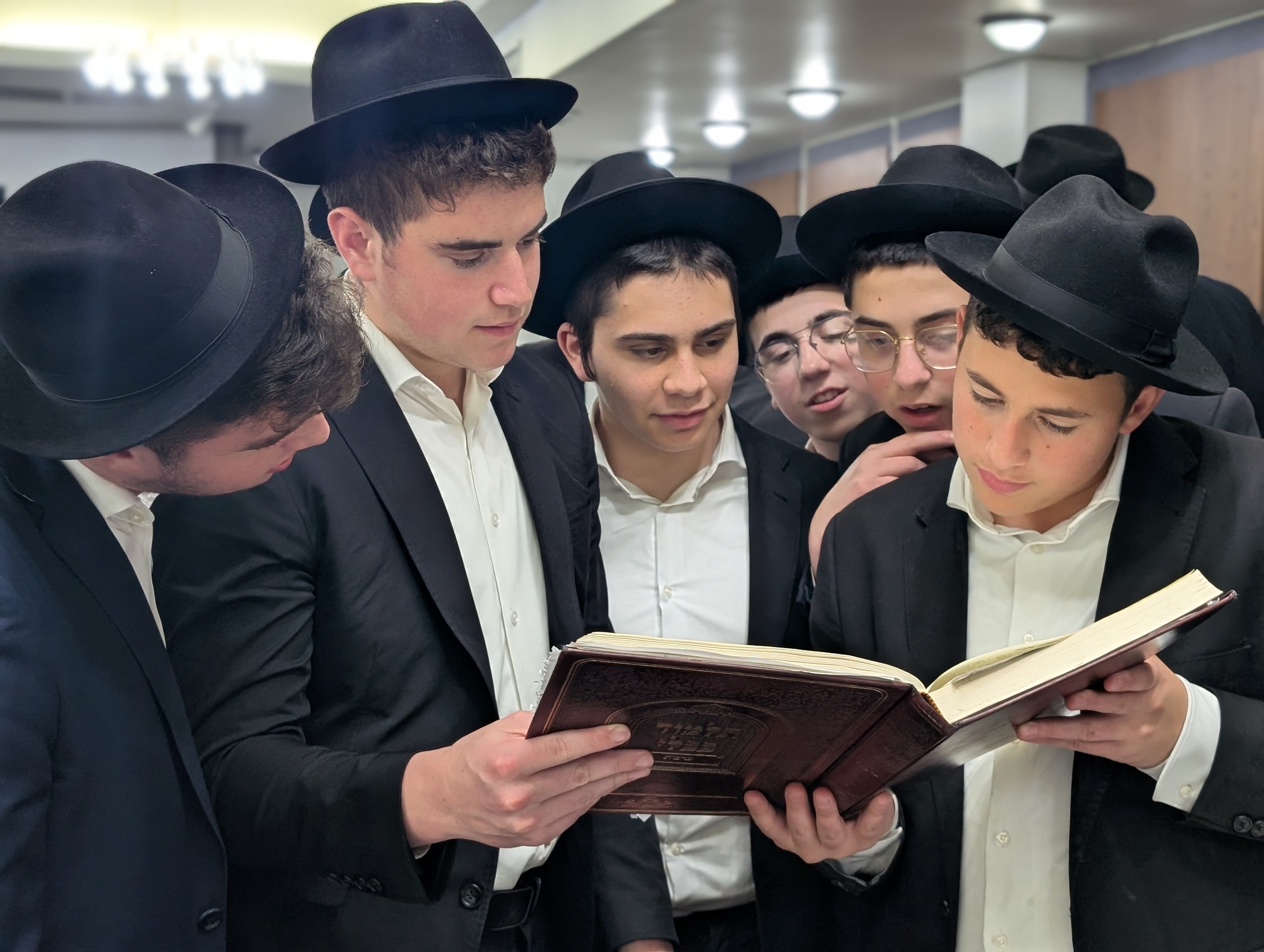 Ner Naftali students learning together around an open sefer